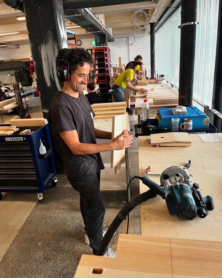 Mehrere Menschen arbeiten in der Werkstatt und bauen unsere neuen Werkbänke.