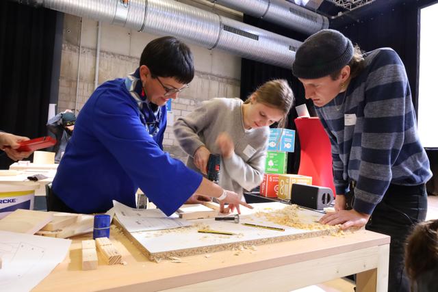 Ein Vogelnistkasten entsteht aus 90 Prozent gerettetem Holz (v.l.): Laura Hebling von der Fachstelle Nachhaltigkeit, eine Schülerin des Kardinal-von-Galen-Gymnasiums Münster und Nick Potter vom Designbüro „studio formagora“. Foto: B-Side Kultur e.V. Veröffentlichung mit dieser Pressemitteilung honorarfrei.