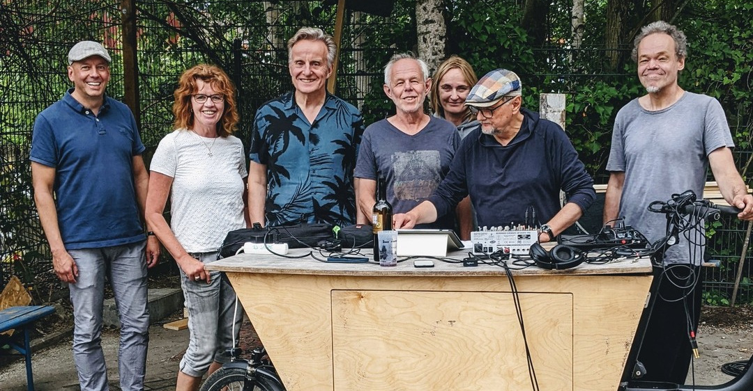 Ein Teamfoto aus dem Sommer 2022. Zu sehen sind sieben Personen, die lächelnd vor einem Lastenrad stehen.