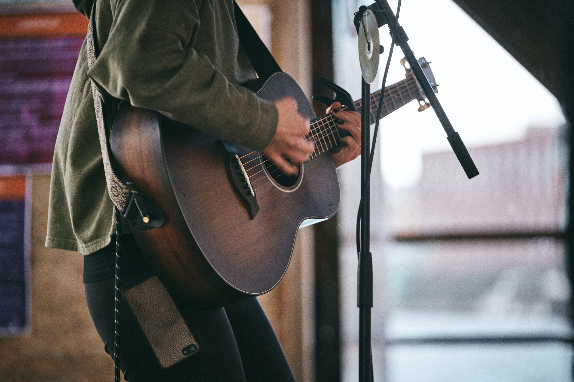 Ein Mensch, der eine Gitarre spielt.  Es ist aber nur der Ausschnitt mit der Gitarre und einer Hande zu sehen.